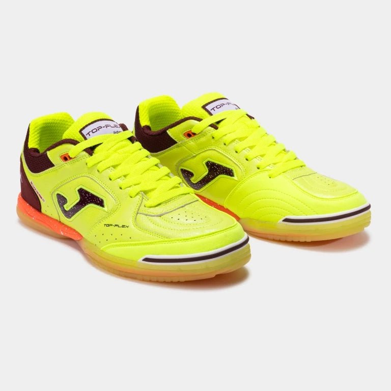 A pair of Joma indoor court shoes in neon yellow and lime with dark brown and orange accents, displayed on a light gray background.