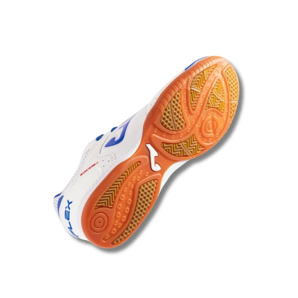A white futsal shoe shown from a high-angle view, displaying its textured orange outsole and blue branding details.