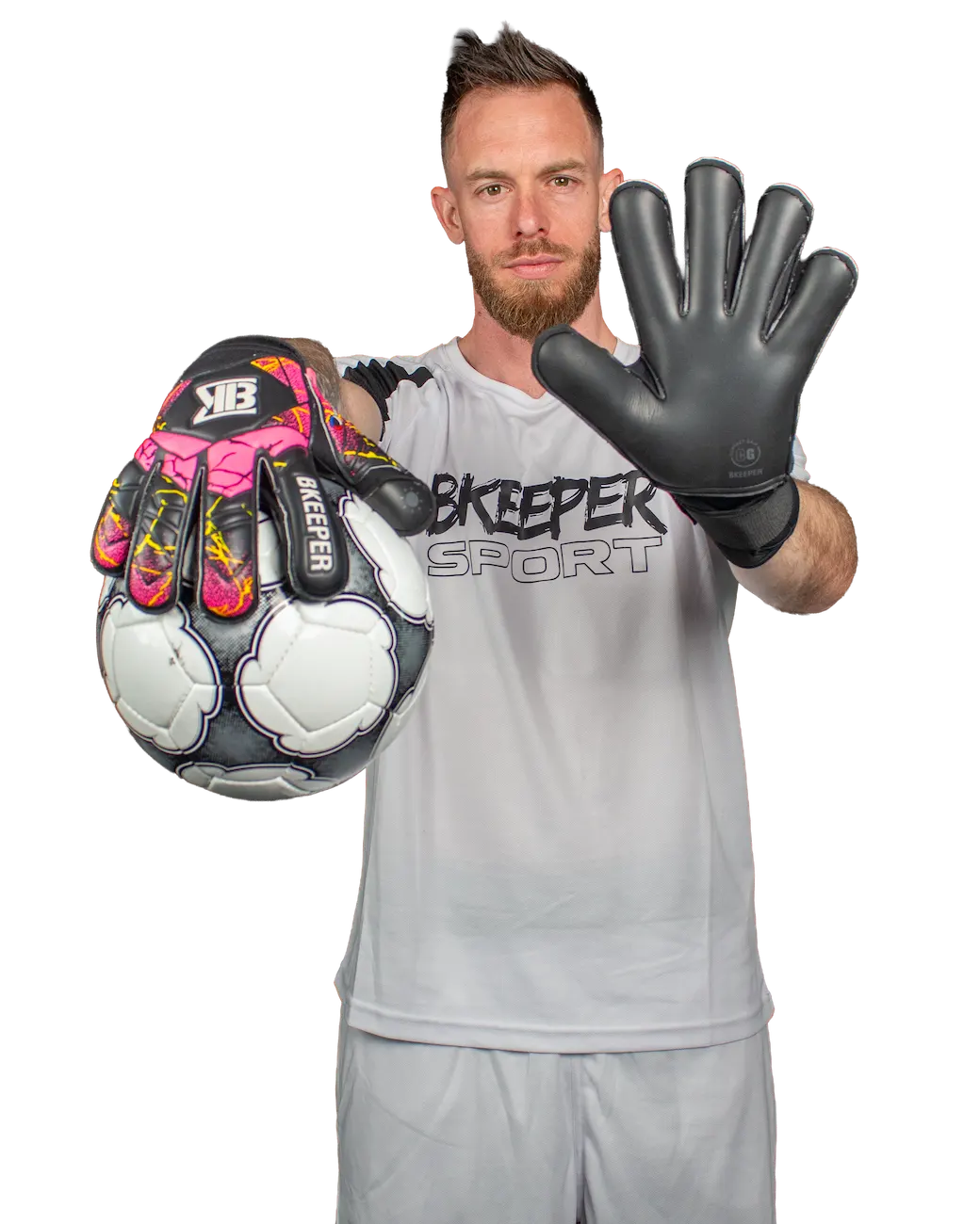 A male goalkeeper wearing a light gray goalkeeper jersey and shorts, holding up a black goalkeeper glove with pink and yellow accents and a soccer ball against a plain white background.