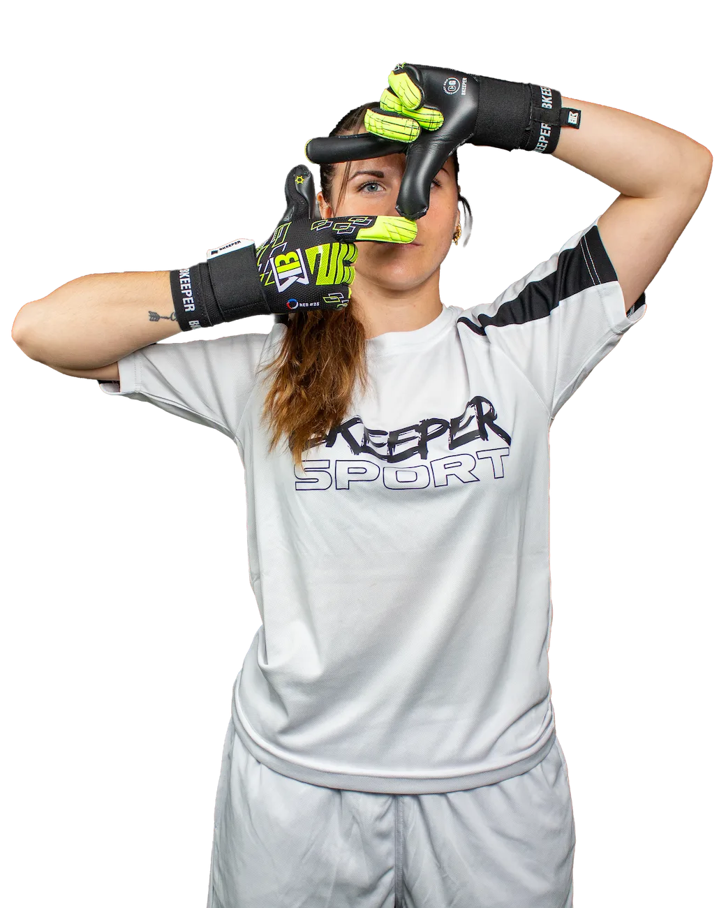 A woman wearing a light gray athletic t-shirt and matching shorts, posing with black and neon green hand gloves in front of her face against a solid white background.